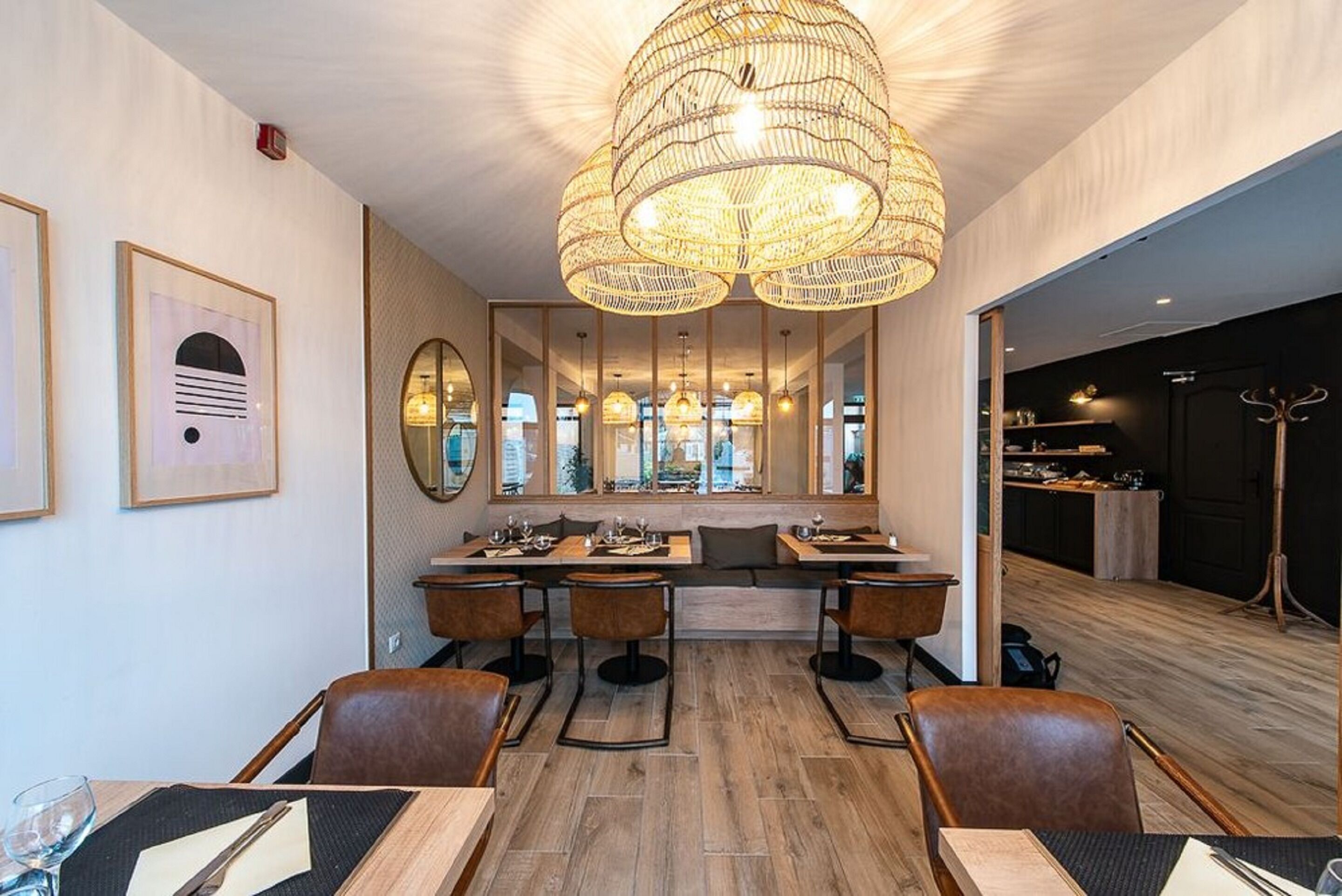 Un interior de restaurante moderno con una zona de estar central, suelo de madera y una gran lámpara de fibra.