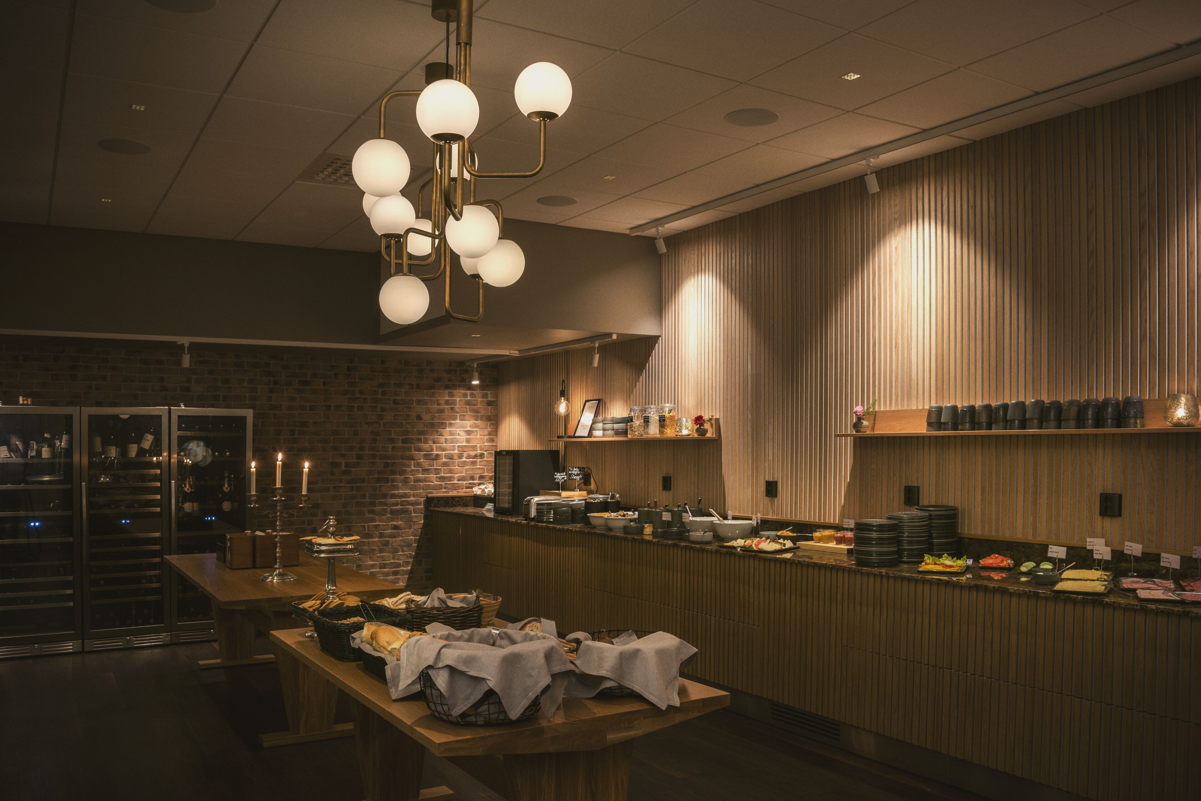 Een buffetopstelling met een houten toonbank, diverse gerechten en een bakstenen muur op de achtergrond.