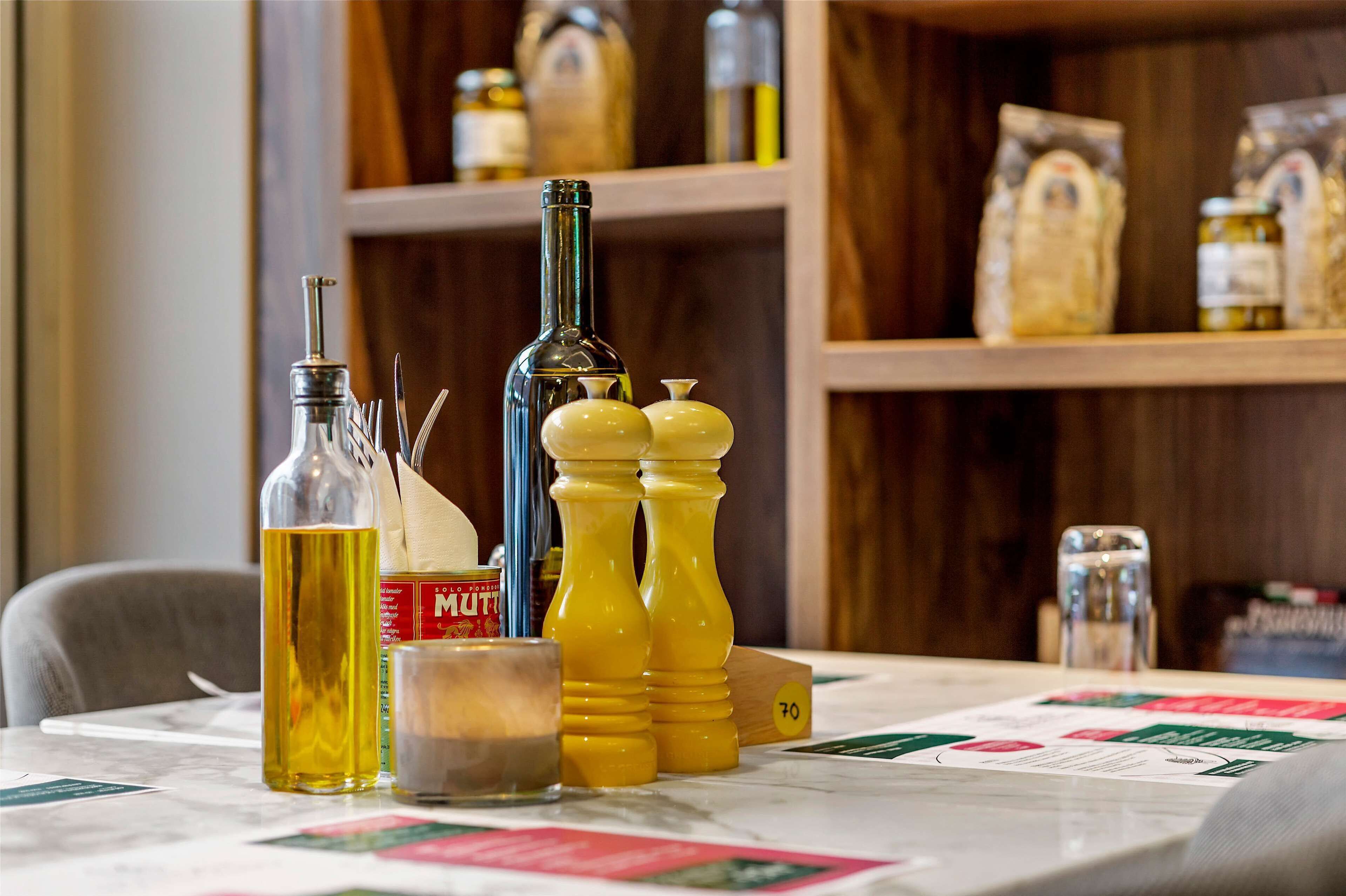 Une table avec des condiments, une bouteille et un salier.