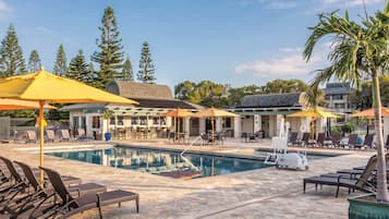 Relax by the pool surrounded by lounge chairs and shaded seating areas.