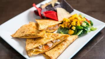 A plate with quesadillas, a side salad, and tortilla chips.