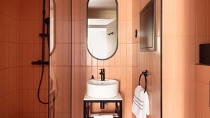 A bathroom with a white sink, a mirror, and a towel rack. - La Dépendance (Paris)