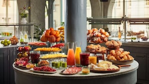 A breakfast buffet with various fruits, pastries, and beverages. - NH Collection Heidelberg (Heidelberg)