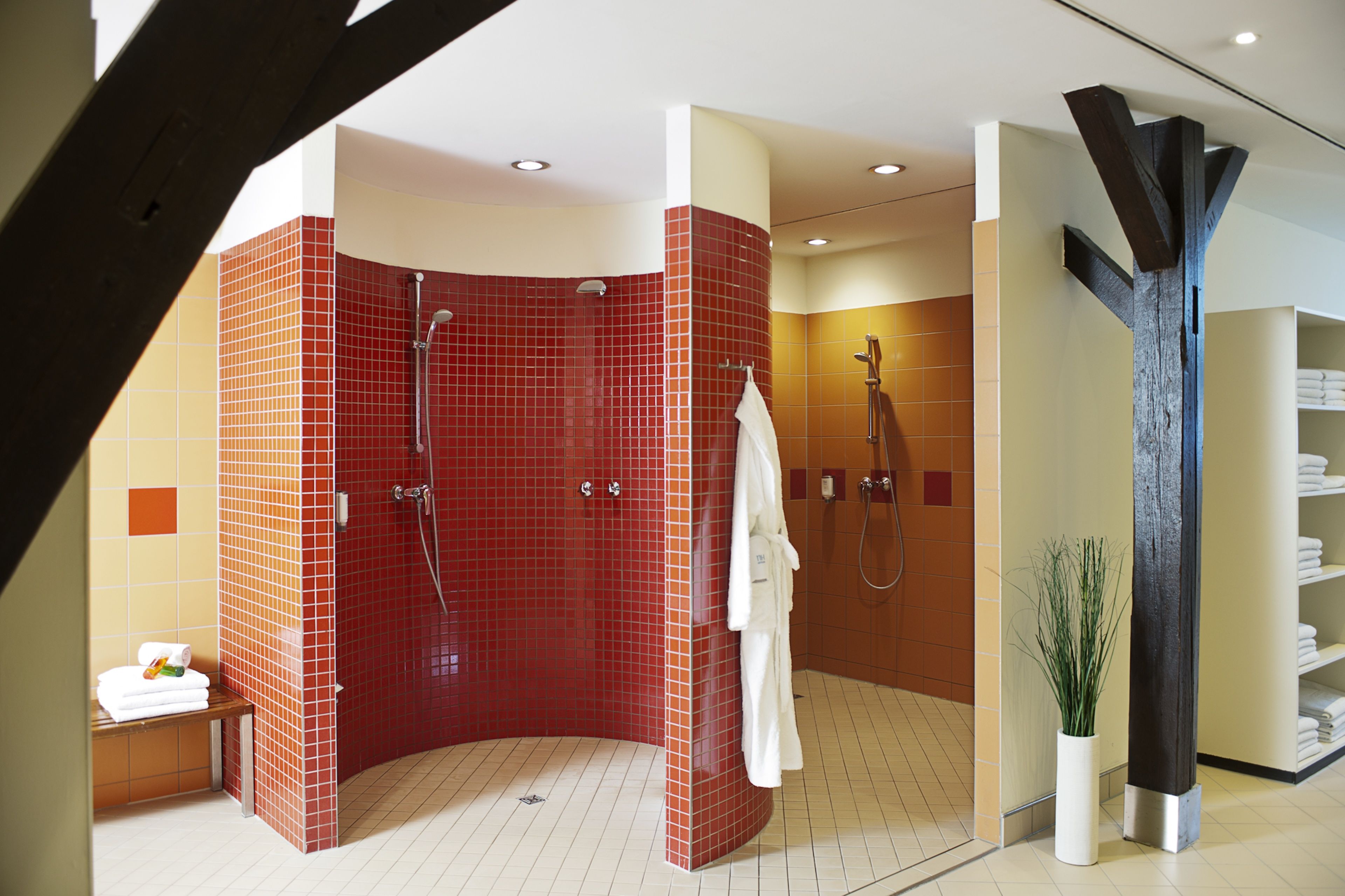 Un baño moderno con una zona de ducha curva, una bañera blanca y un perchero para toallas.