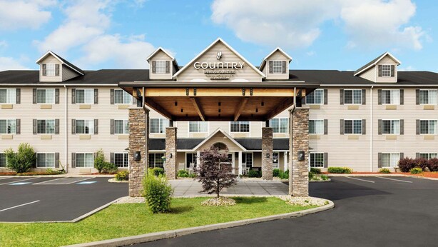 Un hôtel Country Inn & Suites doté d’une entrée couverte, de plusieurs étages et d’un parking.