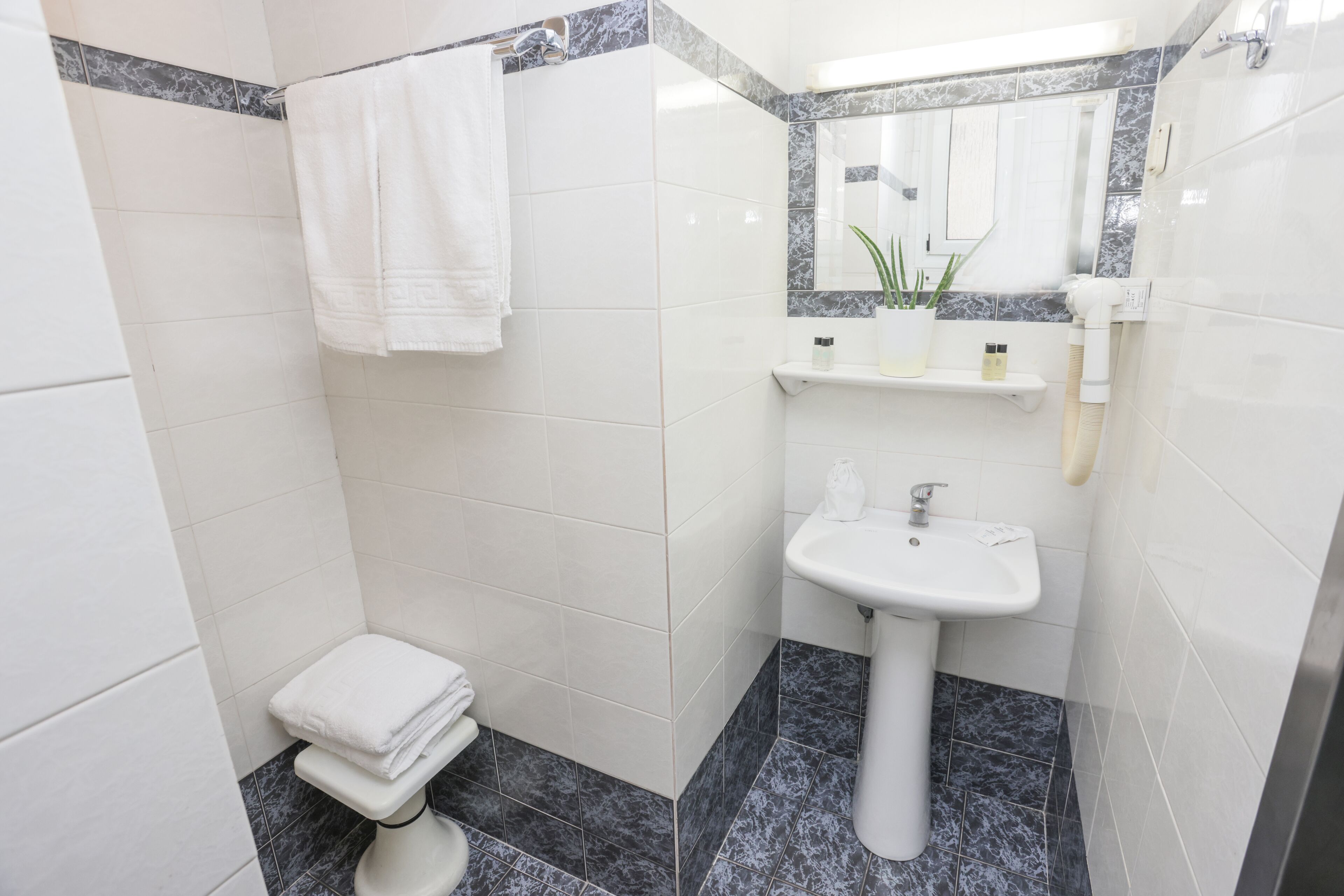 A bathroom with a toilet, sink, and towel rack.