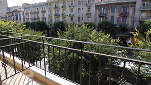 A balcony with a metal railing overlooking a row of multi-story buildings with balconies. - Aegeon Hotel (Thessaloniki)
