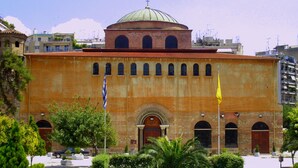 A historic building with a dome, arched windows, and a central entrance. - Aegeon Hotel (Thessaloniki)