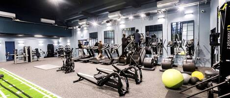 A gym with treadmills, elliptical machines, and free weights.