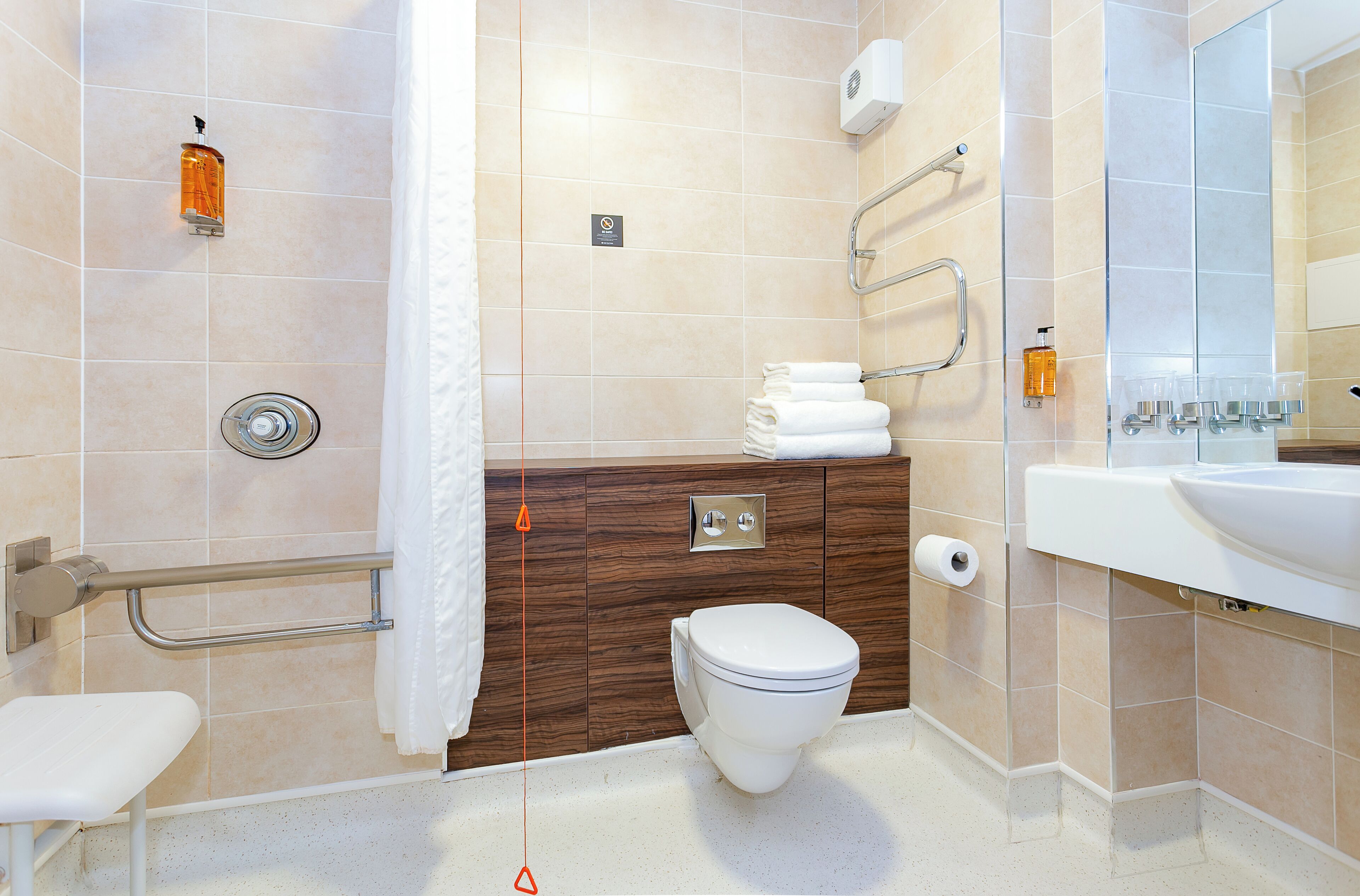 Ein modernes Badezimmer mit Toilette, Waschbecken und Duschbereich.