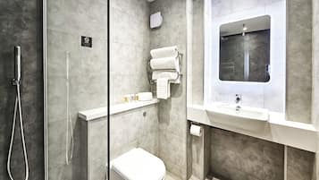 Un baño moderno con ducha, inodoro y lavamanos.