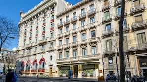 A multi-story hotel with a classic architectural style, featuring balconies and large windows. - Hotel Roger de Lluria Barcelona (Barcelona)