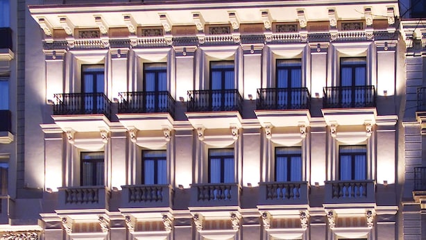 A multi-story hotel with a symmetrical facade, multiple balconies, and a ground-level entrance with a sign. - Hotel Roger de Lluria Barcelona (Barcelona)