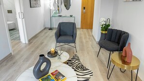 A modern living room with a grey armchair, a round gold table, and a zebra-patterned rug. - Hotel Faranda Los Tilos, Ascend Hotel Collection (Teo)