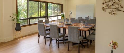 A conference room with a large table, chairs, and a whiteboard.