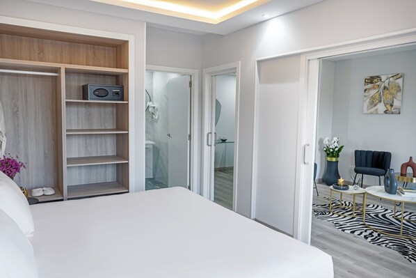 A modern hotel room with a large bed, a walk-in closet, a bathroom with a glass shower, and a living area with a zebra-patterned rug. - Hotel Faranda Los Tilos, Ascend Hotel Collection (Teo)