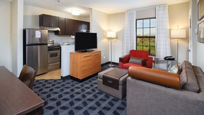 A compact hotel room with a kitchenette, a flat-screen TV, a sofa, and a dining area. - TownePlace Suites by Marriott Tucson (Tucson)