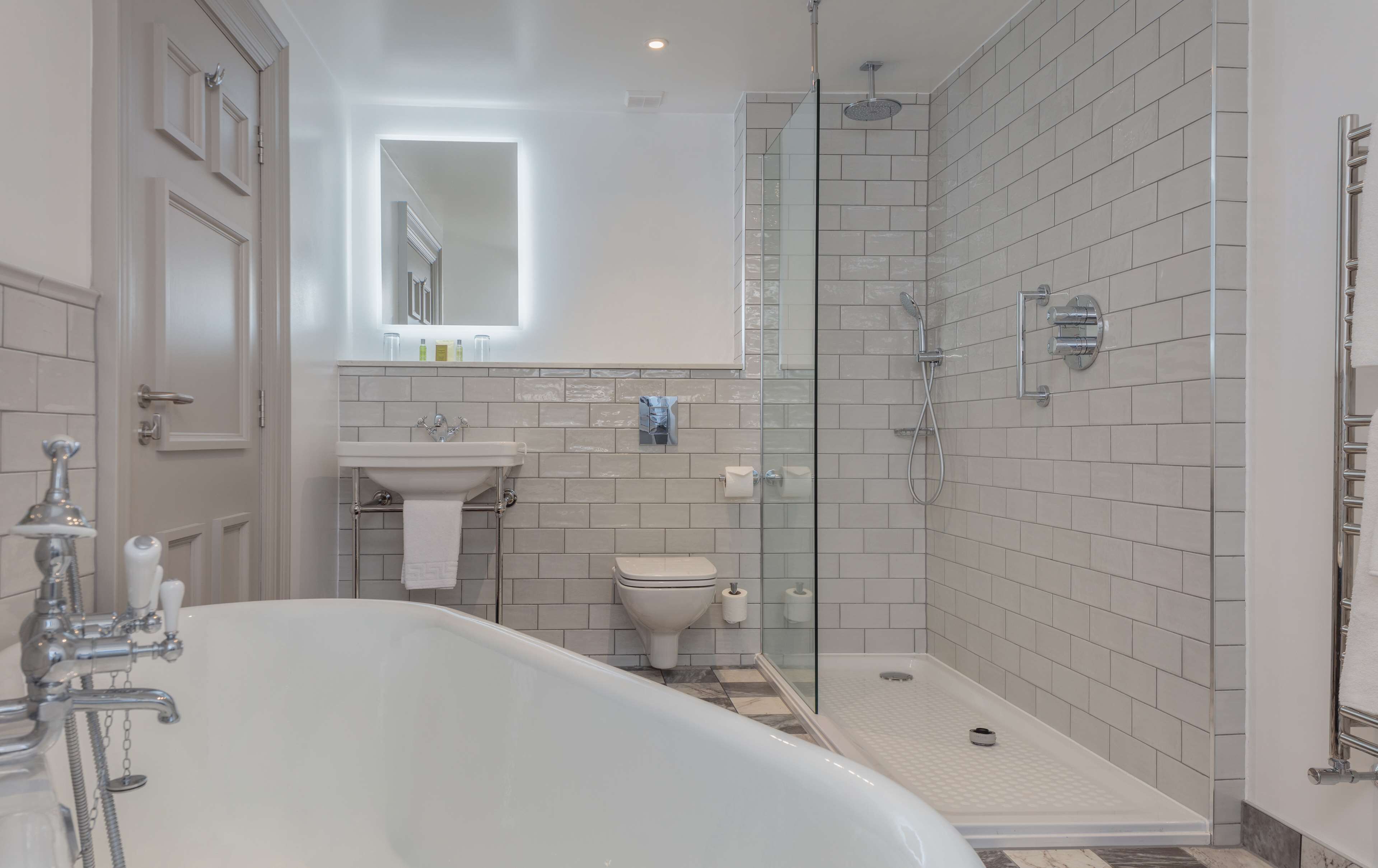 A modern bathroom with a freestanding bathtub, a glass-enclosed shower, and a white toilet.