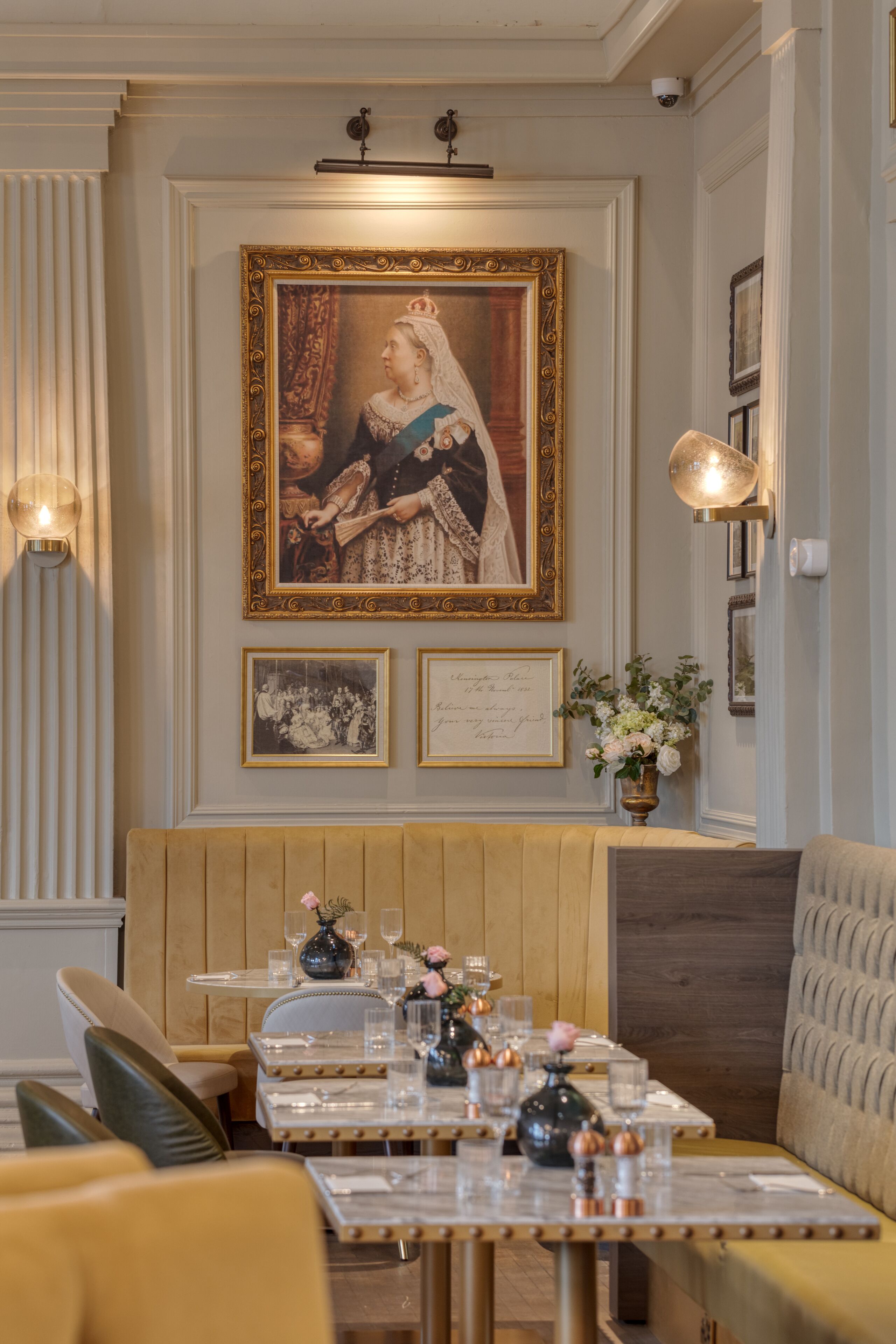 Een eetgedeelte met een tafel voor vier personen, een inlijsting portret aan de muur, en een houten bank.