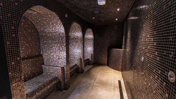Unique tiled design adorns the walls and ceiling, featuring three arched seating areas.