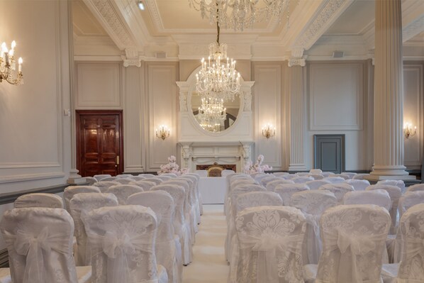 A formal room with rows of chairs, a chandelier, and a fireplace. - DoubleTree by Hilton Harrogate Majestic Hotel & Spa (Harrogate)