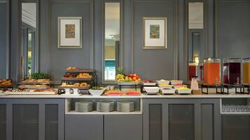 A buffet with various food items and beverages, framed artwork on the wall, and a modern design.