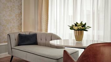 A modern living room with a sofa, a round coffee table, and a vase of flowers.