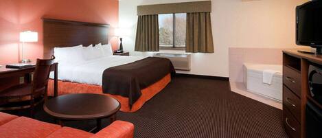 Une chambre d’hôtel avec un lit, un bureau, une chaise, une télévision et une fenêtre avec des rideaux.