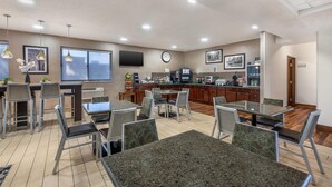 A modern kitchen with a flat-screen TV, a clock, and a coffee machine. - Best Western Des Plaines/O’Hare (Des Plaines)