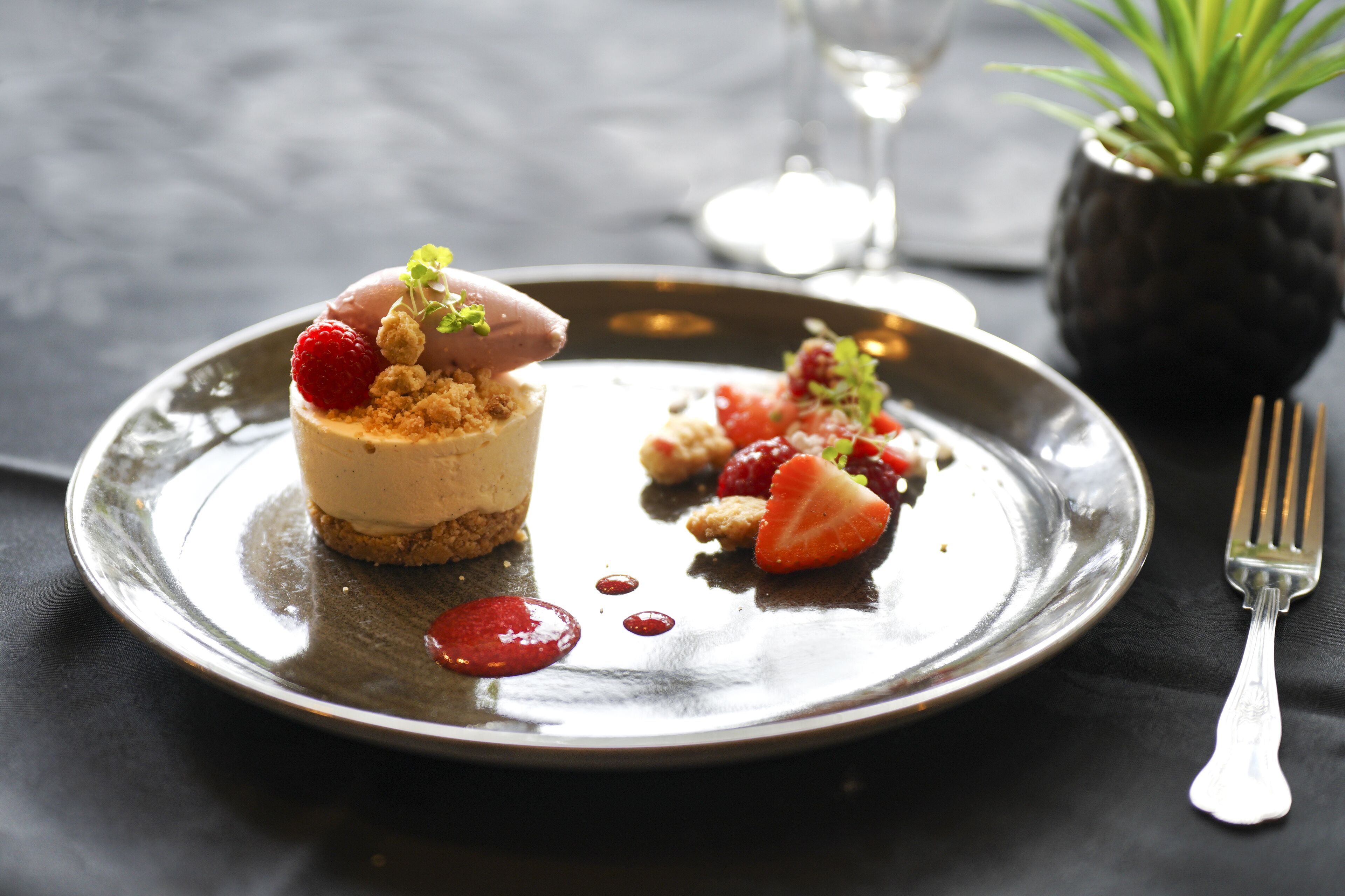 A dessert on a plate with strawberries and a fork.