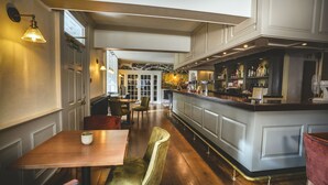 A restaurant with a bar area, wooden flooring, and a view of the restaurant through a glass door. - Best Western Valley Hotel (Telford)