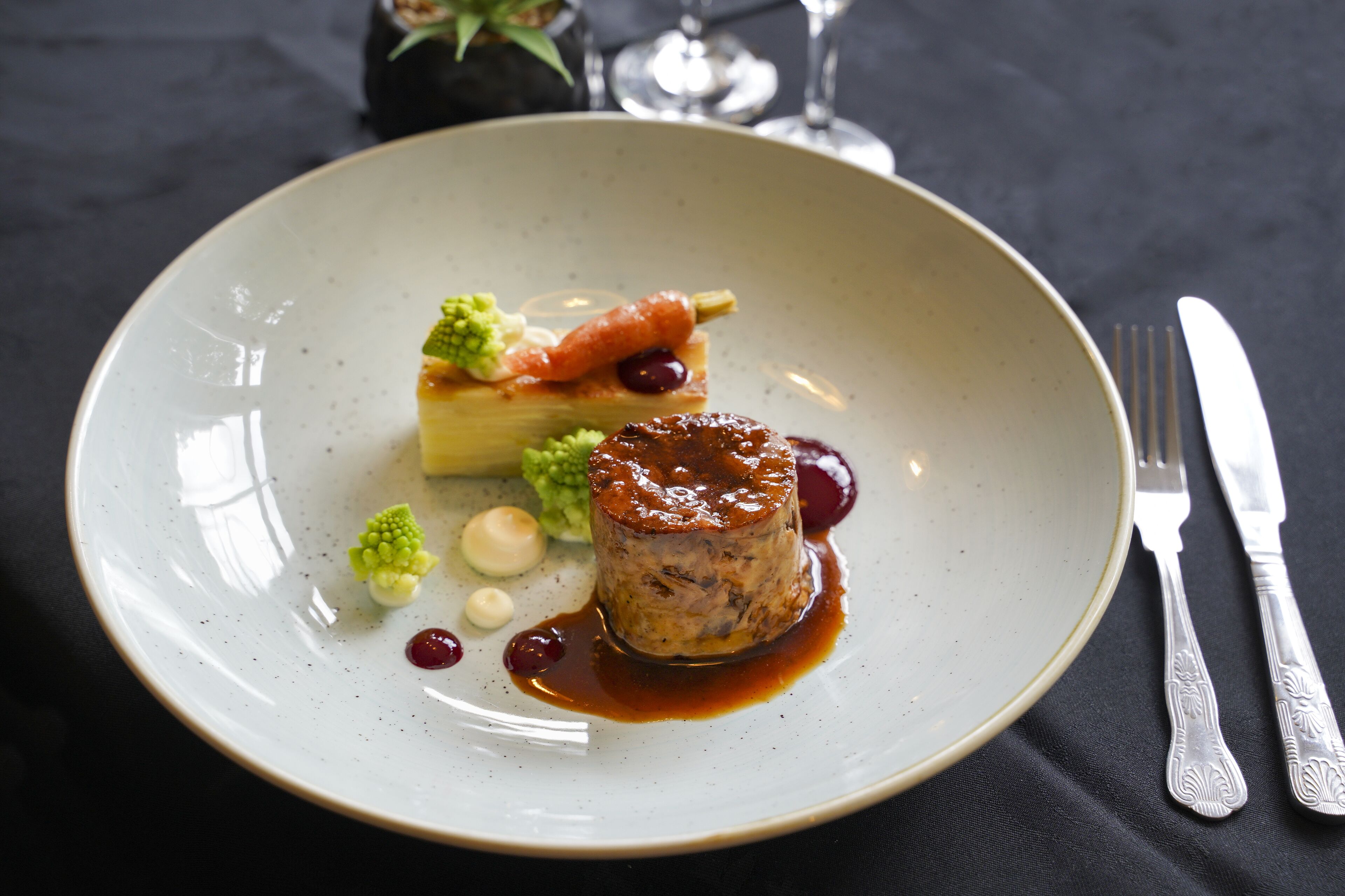 A plate with a dessert, a fork, and a knife on a table.