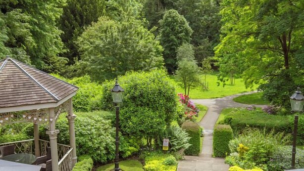 A gazebo with outdoor seating and a pathway leading to a lush garden. - Best Western Valley Hotel (Telford)
