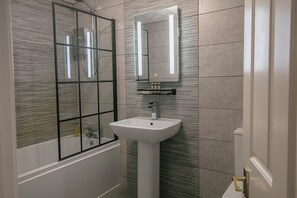 A bathroom with a glass shower enclosure, a pedestal sink, and a wall-mounted mirror. - Best Western Valley Hotel (Telford)