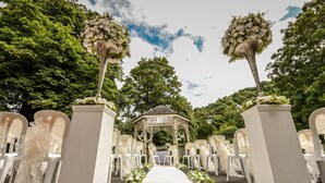 A wedding aisle with white chairs and a gazebo in the background. - Best Western Valley Hotel (Telford)