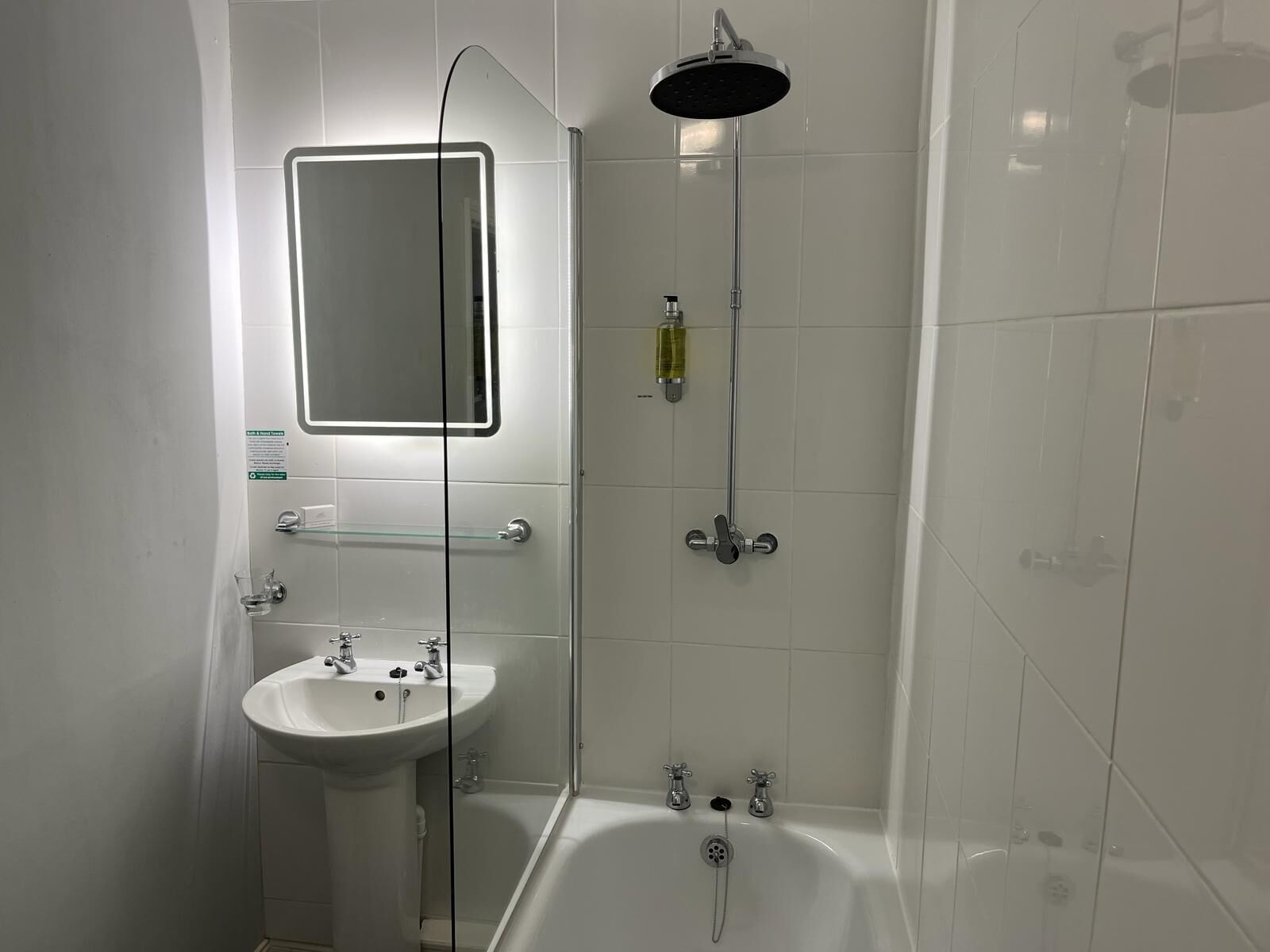 Une salle de bain moderne avec un lavabo blanc, une douche à parois de verre et une baignoire.