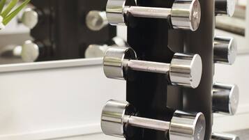 A black vertical dumbbell rack with multiple weight plates.