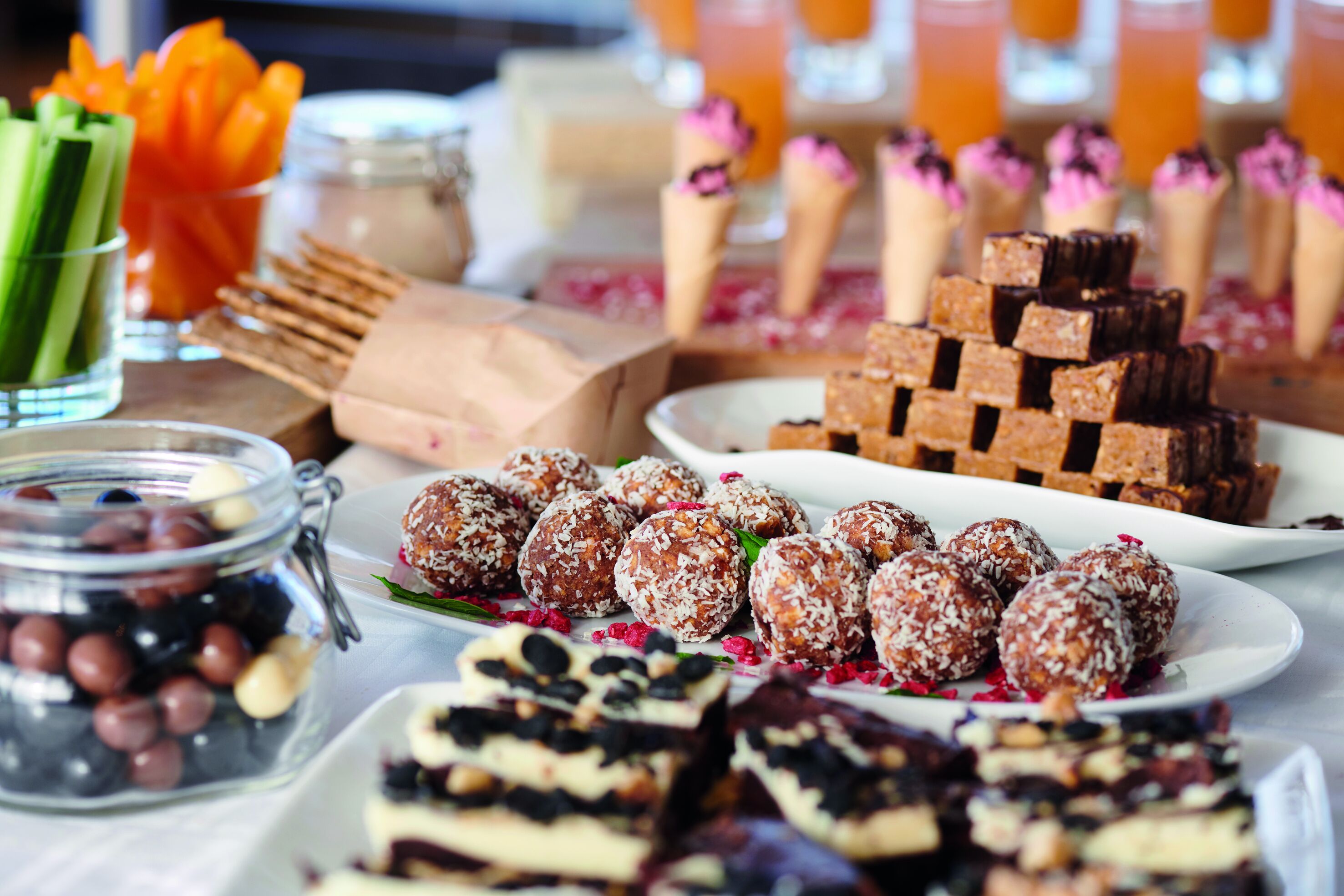 A variety of desserts including chocolate bars, coconut balls, and other sweet treats.