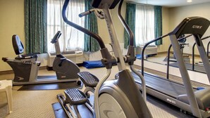 Kuntosali, jossa on juoksumattoja, kuntopyörä ja crosstrainer.