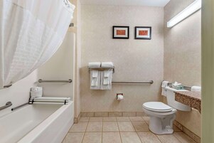 Un baño con bañera, inodoro y perchero para toallas.