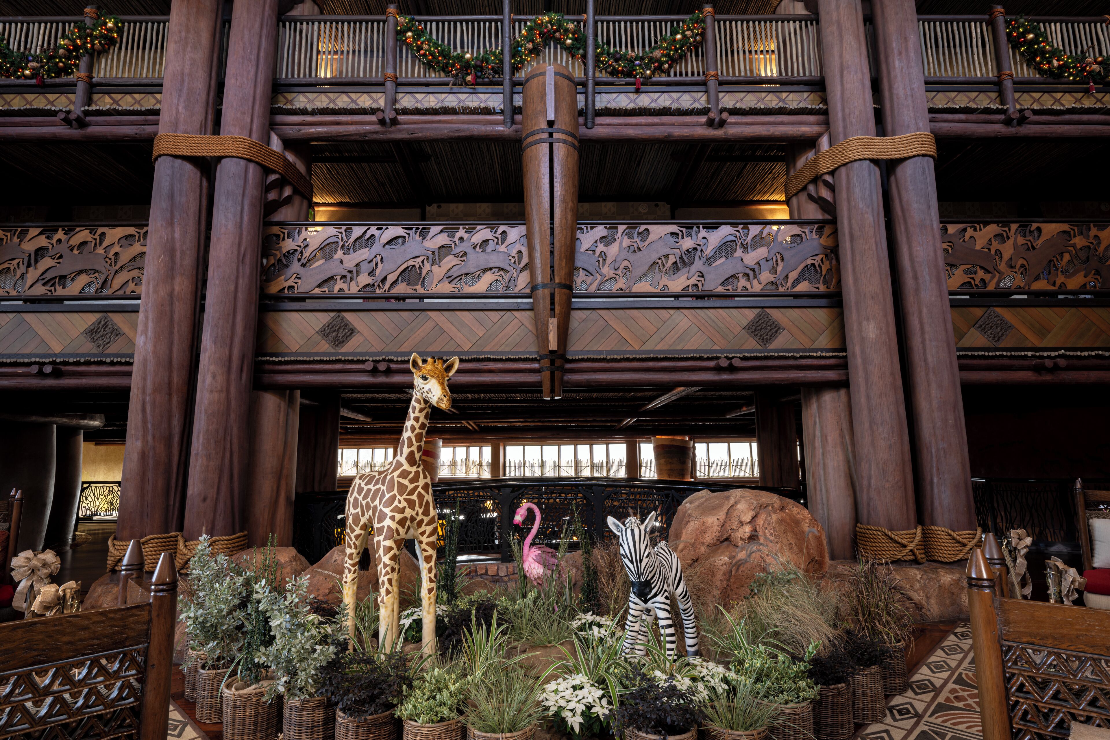 Un hall d’entrée orné d’une statue représentant une girafe et un zèbre, d’un flamant rose et d’un grand bloc de pierre servant de pièce maîtresse.