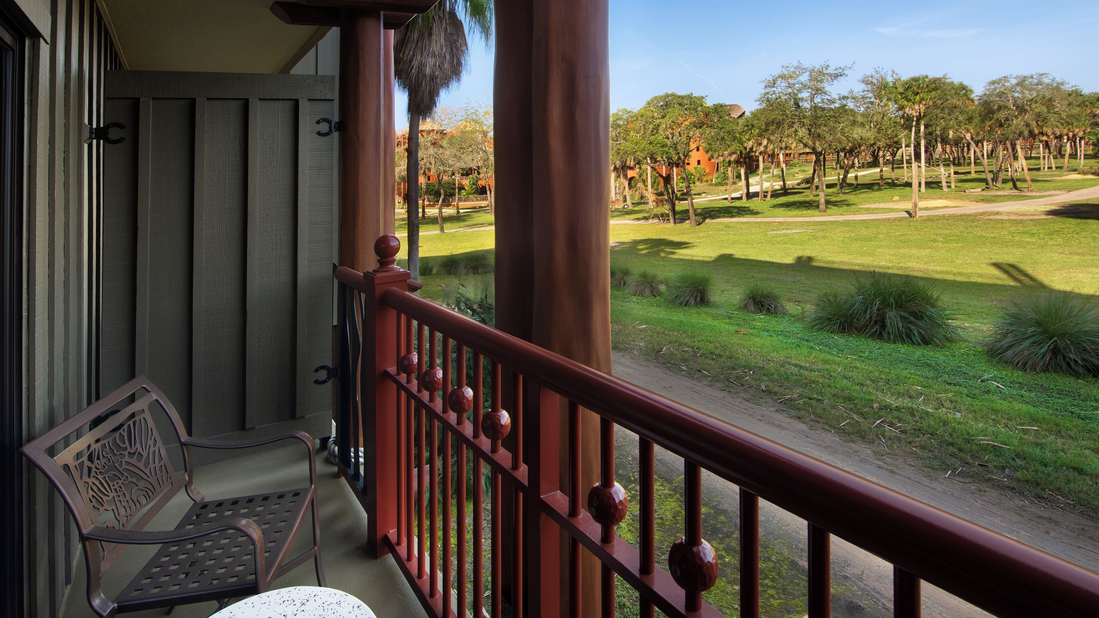 A balcony with a wooden railing, a bench, and a table.