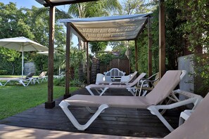 Een buitenzwembad en ligstoelen