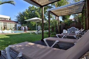 Alberca al aire libre y camastros 