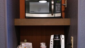 A kitchenette with a microwave, coffee maker, and a Keurig coffee pod dispenser. - Hilton Garden Inn Atlanta Northpoint (Alpharetta)