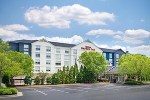 A multi-story Hilton Garden Inn hotel with a parking lot in front. - Hilton Garden Inn Atlanta Northpoint (Alpharetta)