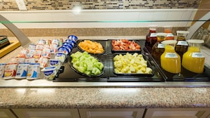 A breakfast buffet with various food items and beverages. - Hilton Garden Inn Atlanta Northpoint (Alpharetta)