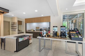 Una cucina moderna con isola centrale, elettrodomestici integrati e vista sull'esterno.