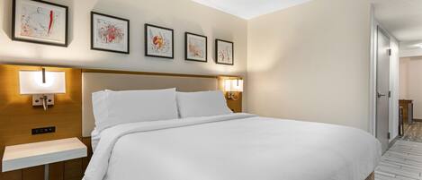 Habitación de hotel con una cama grande, mesitas de noche y una obra de arte colgada en la pared.
