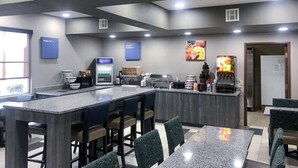 A modern kitchen area with a bar, seating, and various appliances. - Comfort Inn Owasso - Tulsa (Owasso)